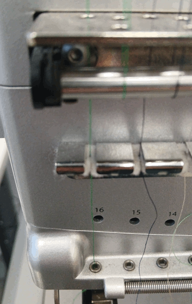 Below the flat and round bar is a flat bar with a felt layer underneath it and notches for each thread to pass through. The thread goes through the notch where it is captured by the felt before going down through a hole below, which leads to the needle.