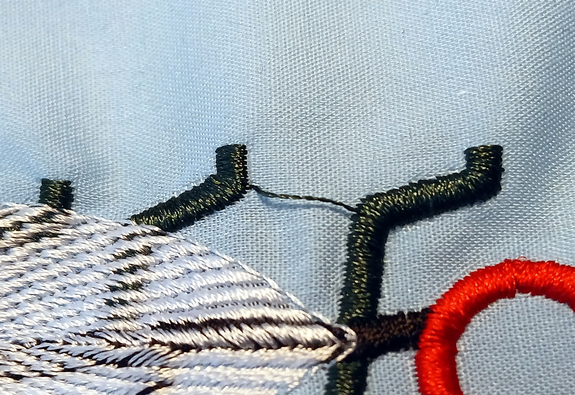 Two satin stitch columns are linked by a floating thread. All threads are of the same color.
